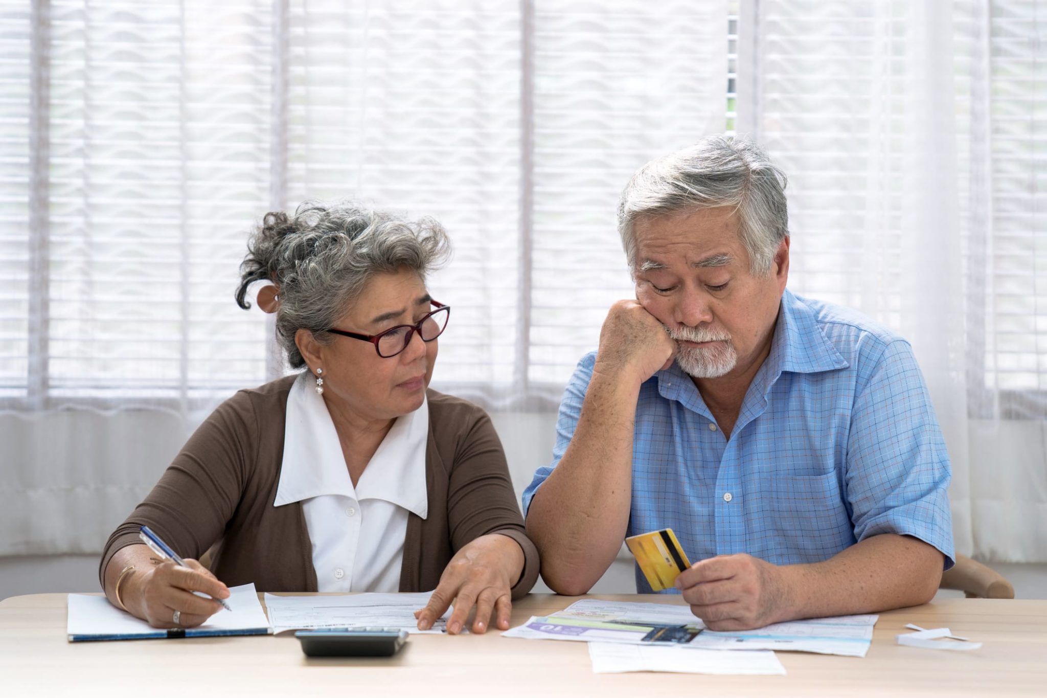 GettyImages-1272625308 Stressed asian couple looking at paperwork